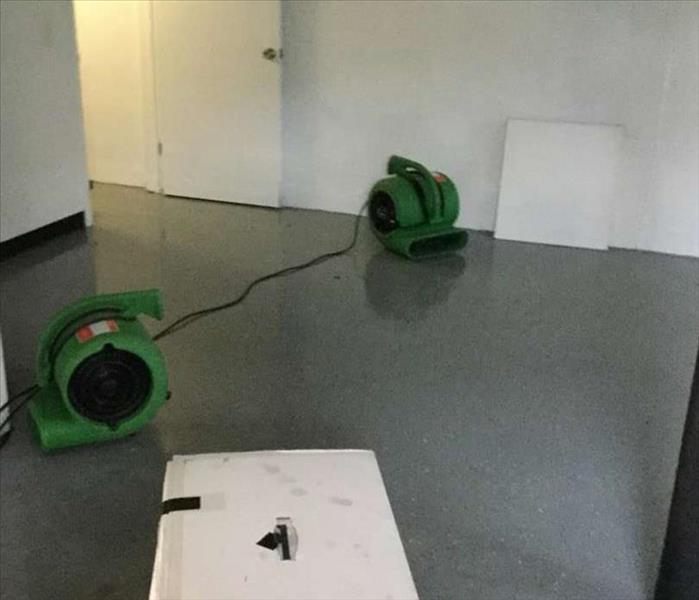 flooded basement now completely dried and without standing water, air movers pictured. 